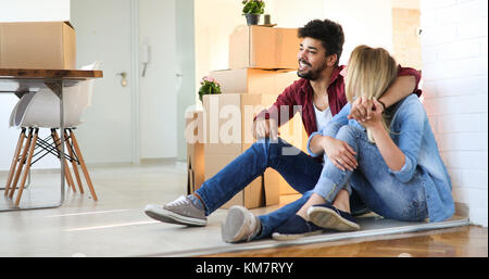 Junge glückliches Paar Umzug in neues Zuhause und Auspacken der Kartons Stockfoto