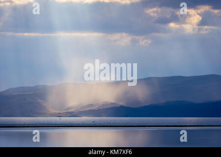 Sturm mit Sonnenstrahlen über die wunderschönen Berge von Song Kul See, Kirgisistan Stockfoto