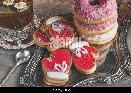 Bunte Weihnachten Donuts und Cookies auf einen hölzernen Tisch in einer rustikalen, gemütlichen Stil. Die horizontalen Rahmen. Stockfoto