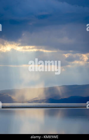 Sturm mit Sonnenstrahlen über die wunderschönen Berge von Song Kul See, Kirgisistan Stockfoto