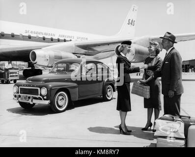 Das Flugzeug SAS DC 8-33, das in den 1960er Jahren am Boden erfasst wurde, zeigt das Flugzeug des Scandinavian Airlines System (SAS). Das Bild zeigt auch eine Bodengastgeberin, die den Passagieren hilft. Stockfoto
