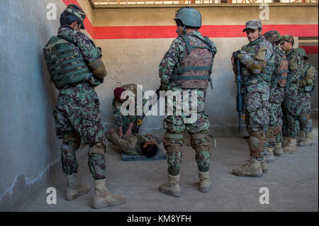 Ein afghanischer commando Ausbilder unterrichtet Rekruten, wie man richtig ein feindlicher Kämpfer Suche während urban Operations Training im Camp Commando, Kabul, Afghanistan, sep. 18, 2017 nach Abschluss des Studiums von der commando Qualifikation Kurs, der neue Kommandos wird eine spezielle Operationen kandak, die in eine der sechs Regionalen afghanischen nationalen Armee Korps Verantwortungsbereich. Die commando Kraft führt 70 % der offensive Operationen in Afghanistan. Stockfoto