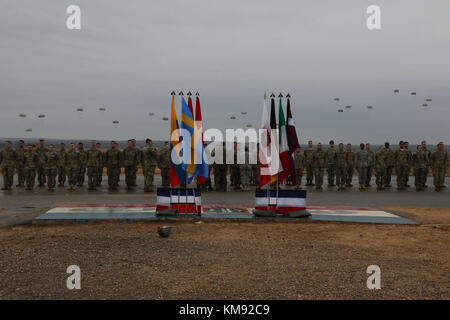 Us-Armee Fallschirmjäger Line up in der Ausbildung ihrer ausländischen springen Flügel von einem ausländischen Jumpmaster zu erhalten, die nach ihrem Abstieg auf Sizilien Drop Zone in Fort Bragg, North Carolina am Dez. 2, 2017. "Springen Tag" ist der zweite in einer zweitägigen Veranstaltung im Rahmen der 20. jährlichen Randy Oler Memorial Betrieb Spielzeug Fallen, bewirtet durch die US-Armee die zivilen Angelegenheiten & psychologische Operations Command (Airborne). Betrieb Spielzeug Drop ist der weltweit größte kombinierten Betrieb mit acht Partner Nationen Fallschirmjäger in diesem Jahr beteiligen. Es gibt Soldaten die Gelegenheit und können auf Ihre militärischen Berufliche Schulen Stockfoto