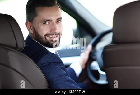 Unternehmer sitzen am Steuer eines Autos, und wenn man die Kamera Stockfoto