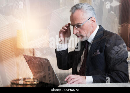Schwere reifen Geschäftsmanns, der auf dem Laptop Stockfoto