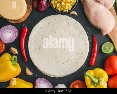 Blick von oben auf die ingridients für die Vorbereitung der mexikanischen Chicken Quesadilla auf dem Schwarzen Tisch. Platz für Text. Stockfoto