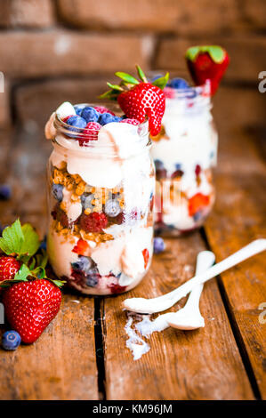 Müsli Parfait mit Joghurt und Beeren auf rustikalen Hintergrund Stockfoto