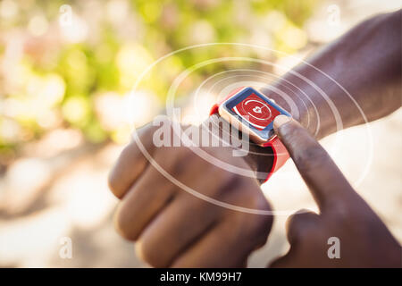 Digital composite von Herz Symbol gegen den Menschen zeigen über Smart Watch Stockfoto