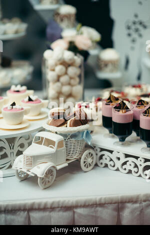 Hochzeit Tisch set Dessert auto Dekor Obst Schokolade macarons Vertikale essen Süßigkeiten. Stockfoto