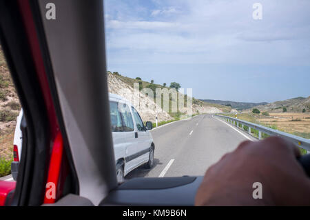 Treiber werden auf der lokalen Straße überholt. Blick aus dem Inneren des Autos Stockfoto