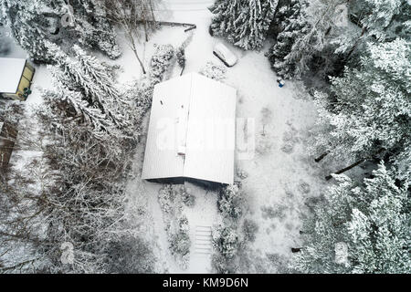 Familie Haus in einem Wald nach dem ersten Schneefall, Luftaufnahme mit Drone Stockfoto