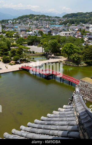 Matsumoto - Japan, Juni 6, 2017: rote Brücke über den Burggraben aus gesehen die Burg Matsumoto auch als die Krähe Schloss bekannt.