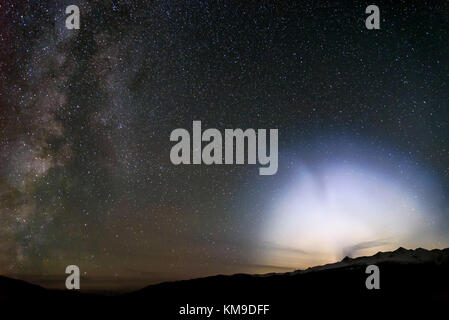 Ein buntes Panorama der Sternenhimmel mit der Milchstraße, eine schöne ungewöhnliche Halo aus dem Ufo und Sterne in den nächtlichen Himmel über den Bergen Stockfoto