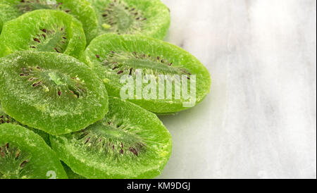 Mehrere Scheiben verglast Kiwi auf grauem Marmor Schneidebrett. Stockfoto
