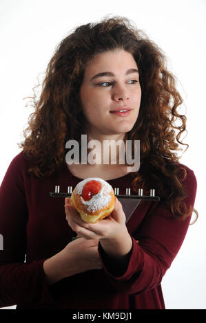 Jüdische Feiertag Hanukkah - schöne Frau mit süßen sufganiyot (Donuts) und menorah Stockfoto