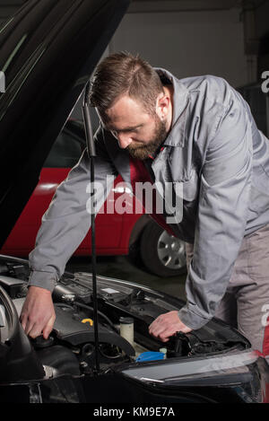 Mechaniker Prüfen des Ölstands Kappe in einem Auto Motor Stockfoto