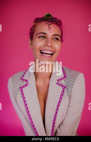 Porträt einer Frau mit Klammern und rosa Haare lachen Stockfoto