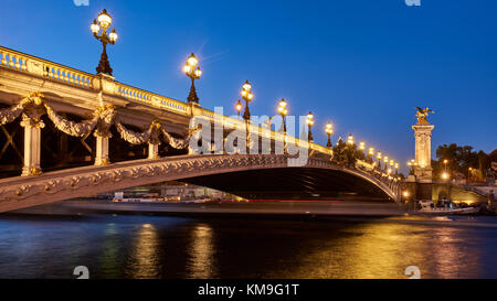 Panoramablick auf die Pont Alexandre III Brücke beleuchtet am Abend mit dem Fluss Seine. 8. Arrondissement, Paris, Frankreich Stockfoto