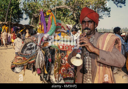 Hippie Flohmarkt, Flöte Spieler mit Kuh an Anjuna Beach, North Goa, Indien Stockfoto