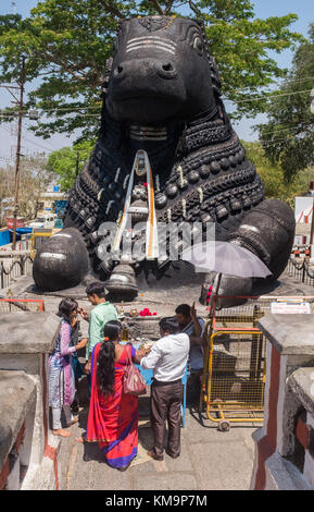 Touristen beten vor dem Nandi-Stier am Chamundi Hill in Mysore, Mysuru, Karnataka, Indien. Stockfoto