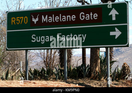 Kruger National Park, Mpumalanga, Schild zeigt Richtung Malelane Gate und Zuckerfabrik Stockfoto