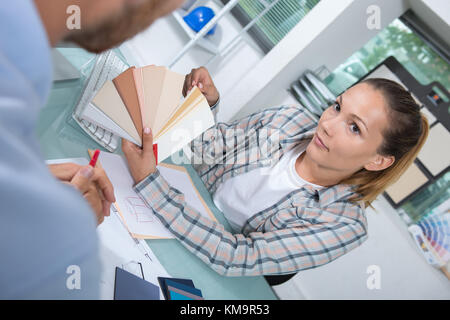 Junge Frau mit Farbe Muster oder Proben, die an den Kunden Stockfoto