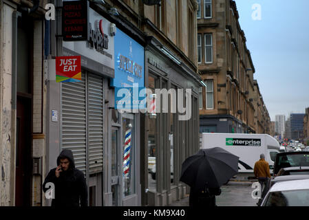 Mädchen mit Schirm regnerischen Tag nass Argyle Street im finnieston, Glasgow, Vereinigtes Königreich Stockfoto