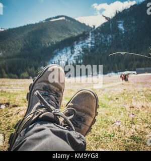 Beine von Reisenden, mit wunderschöner atemberaubenden Bergblick, Freiheit Konzept Stockfoto