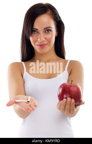 Eine junge Frau, die in einer Hand eine Zigarette in der anderen gesunden apple Zigarre rauchen aufhören Konzept auf weißem Hintergrund Stockfoto