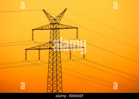 Hohe Spannung Strom pylon/Getriebe Turm vor Sonnenuntergang Silhouette Stockfoto