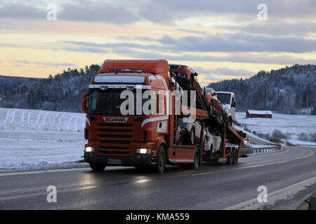 Salo, Finnland - Dezember 2, 2017: rote Scania R480 Car carrier Hols neues Auto in der Dämmerung entlang der Autobahn im Winter. Stockfoto