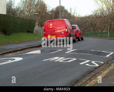 Red Royal Mail Post van mit ironischen langsam Fahrbahnmarkierung Schild an der Straße geparkt Stockfoto