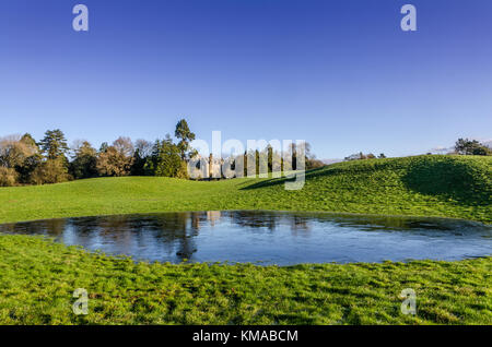 Ein Landhaus mit einem gefrorenen Teich im Winter. Stockfoto