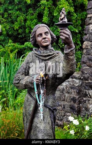 St. Brigids heiliger Brunnen, frühe heidnische und keltisch-christliche Stätte in der Nähe der Stadt Kildare, Co. Kildare, Irland. Statue des heiligen Brigid Stockfoto