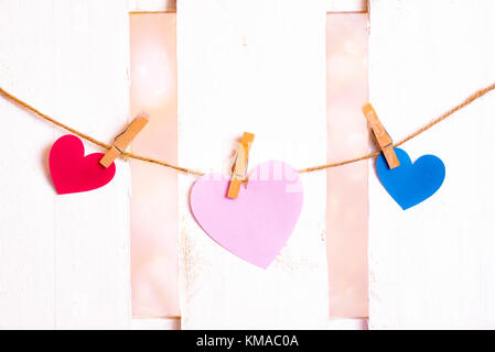 Valentinstag Bild mit einem großen rosa Herz in der Mitte, eine rote und eine blaue auf den Seiten ist aus Papier und in einen String mit Holz- Clips gebunden Stockfoto