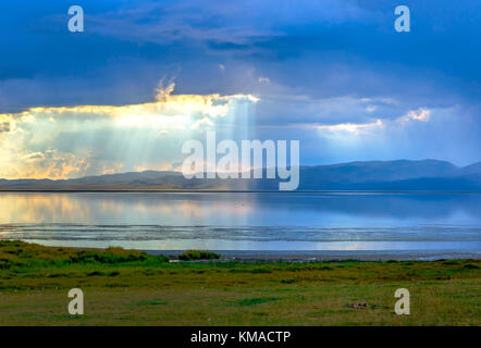 Sturm mit Sonnenstrahlen über die wunderschönen Berge von Song Kul See, Kirgisistan Stockfoto