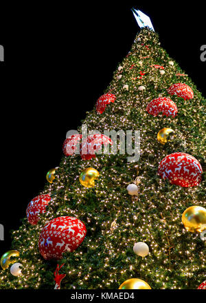 Low Angle View eines riesigen glitzernden Weihnachtsbaum mit vielen bunten und glänzend Ornamenten verziert Stockfoto