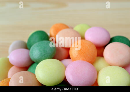 Bis geschlossen Haufen bunte runde Bonbons auf hölzernen Hintergrund mit selektiven Fokus Stockfoto