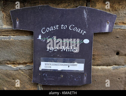 Schild in Form eines T-Shirt zeigt Ende von Küste zu Küste Pfad, Robin Hood's Bay. Stockfoto