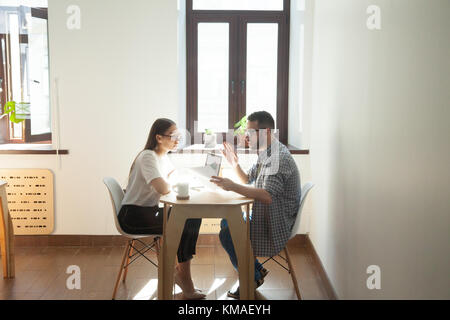 Kaufmann und Kauffrau diskutieren die Probleme im Amt. Zwei tausendjährige Mitarbeiter in business meeting und Argumentieren job Fragen Stockfoto