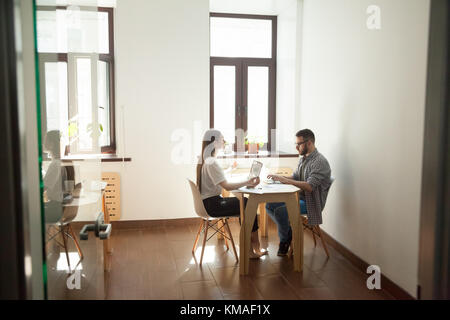 Friedliche eingedenk Geschäftsfrau yoga meditation im Büro Schreibtisch während die Kollegen arbeiten Stockfoto