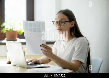 Millennium schöne weibliche Designerin mit pantone-Farbpalette. Junge Frau, die an einem Laptop arbeitet und Hausdesign macht Stockfoto