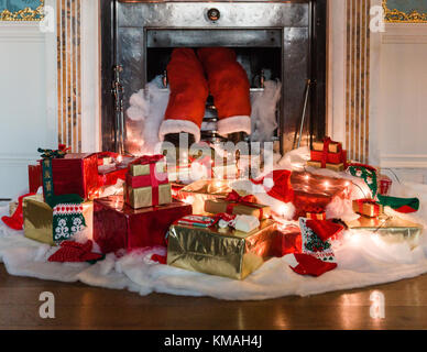 Pater Christmas scheint festzuhalten, als er das Weihnachtsfest umgab, umgeben von seinen Geschenken. Stockfoto