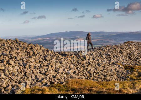 Ein Wanderer auf den Ruinen der Eisenzeit Tippen O Noth Hill Fort auf dem Hügel O Noth in der Nähe von Rhynie, Aberdeenshire, Schottland, berühmt für seine verglaste Steinmauern Stockfoto