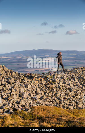 Ein Wanderer auf den Ruinen der Eisenzeit Tippen O Noth Hill Fort auf dem Hügel O Noth in der Nähe von Rhynie, Aberdeenshire, Schottland, berühmt für seine verglaste Steinmauern Stockfoto