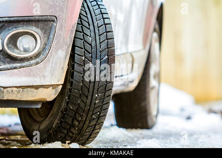 Close-up Auto Rad Reifen im Winter auf verschneiter Straße Stockfoto