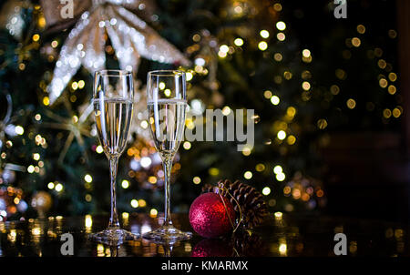 Zwei Sektgläser von Weihnachtsschmuck umgeben Stockfoto