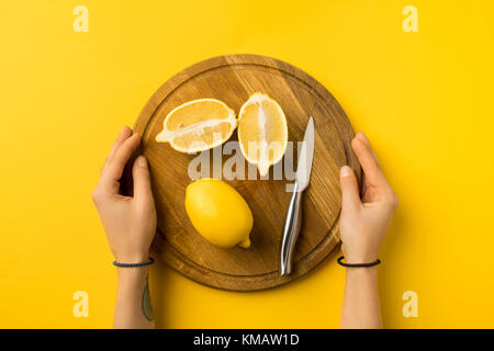 Frau mit Holzbrett mit Zitronen Stockfoto