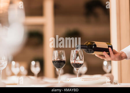 Kellner gießen Rotwein Stockfoto