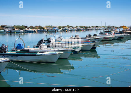 Kleine Fischerboote vertäut am Ufer entlang in fuseta an der Ria Formosa, Portugal. Stockfoto